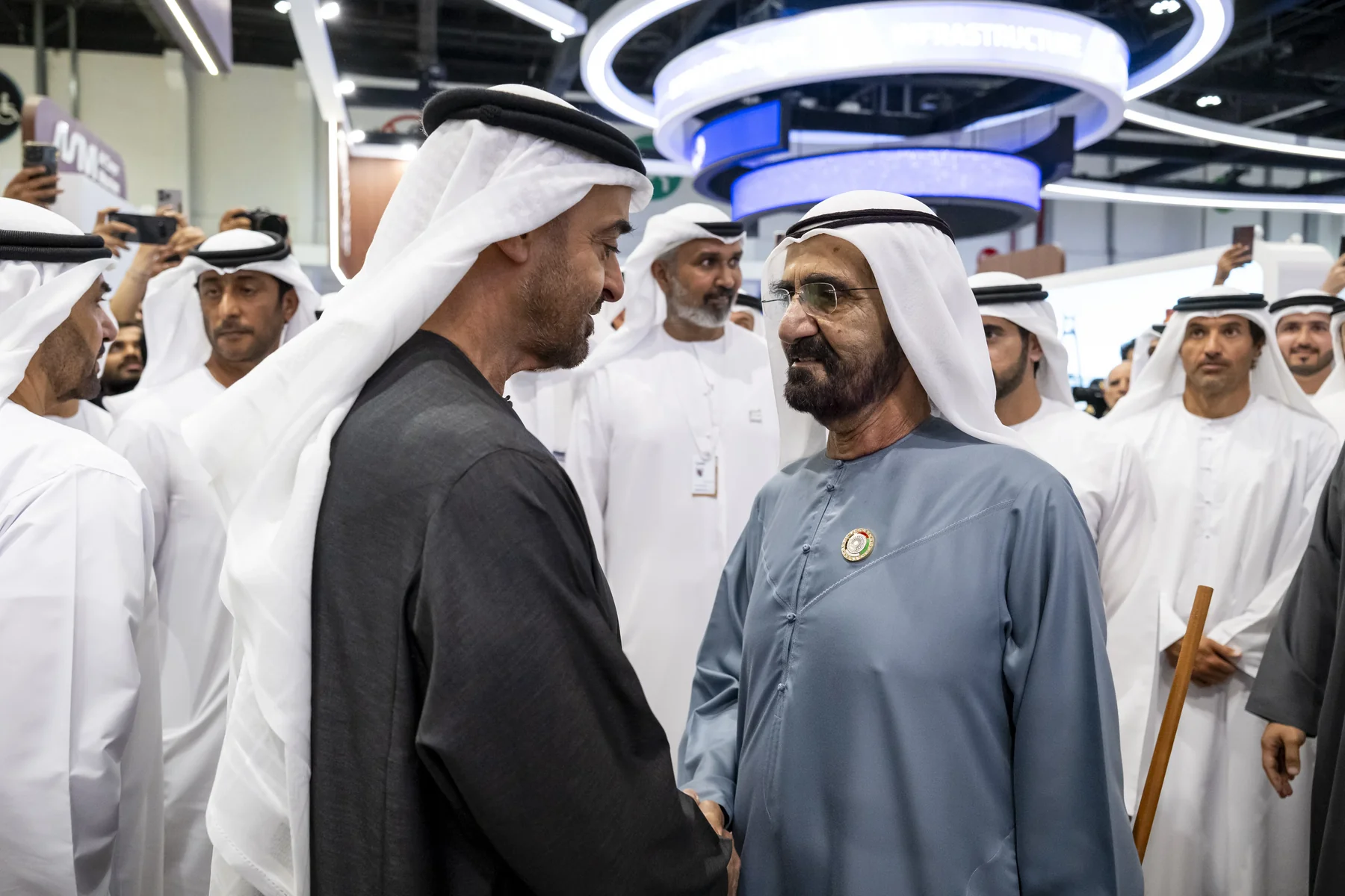 Senior figures greeting on the floor of an Abu Dhabi finance event